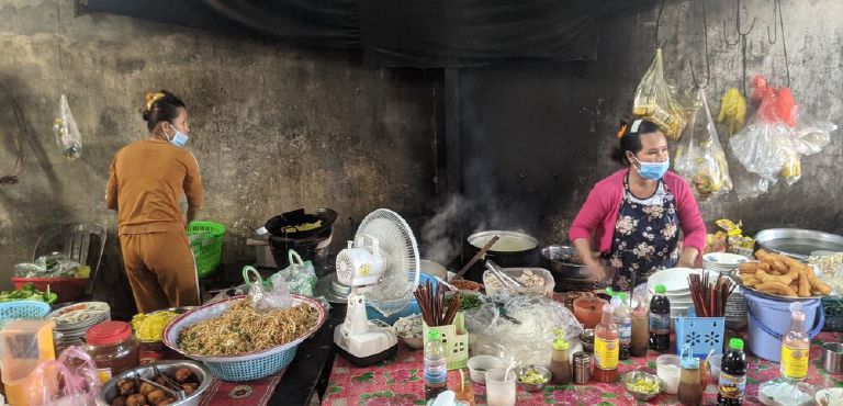 Street food vendors at a Kampot market breakfast stall