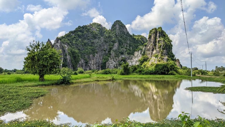 Limestone karst hills reflected in flooded rice paddies at Kampong Trach, near Kampot